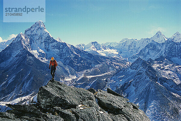 A man climbs across a ridge top near Ama Dablam  Khumbu Valley  Nepal.