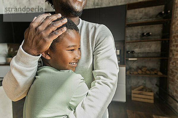 African American man hugging his son in sign of family love