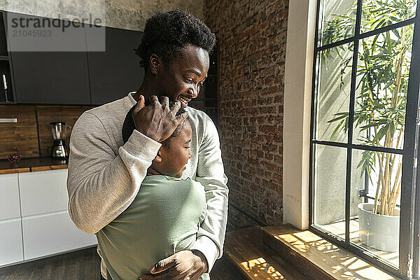 African American man hugging his son in sign of family love