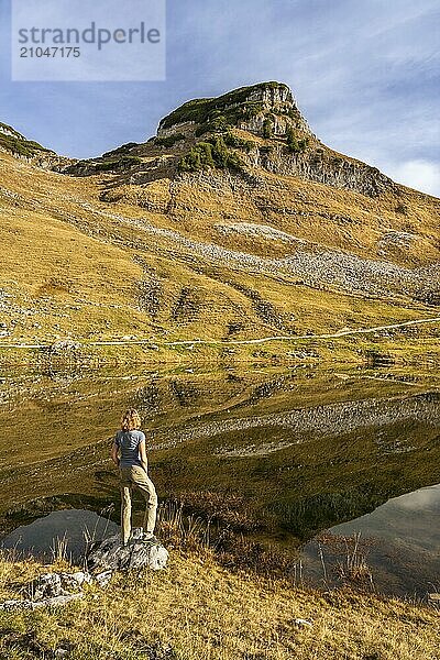 Augstsee und der Berg Atterkogel auf dem Loser. Eine Wanderin steht am Ufer. Herbst  gutes Wetter  blauer Himmel. Spiegelung. Altaussee  Bad Aussee  Ausseer Land  Totes Gebirge  Steiermark  Oberösterreich  Österreich  Europa