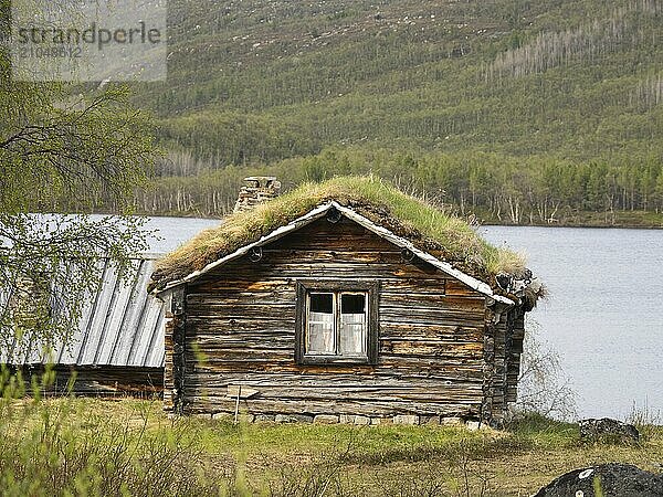 Ferienhaus am Rande eines Sees  teilweise im Stil der traditionellen Behausungen der samischen Ureinwohner gebaut  Mai  Finnmark  Norwegen  Europa