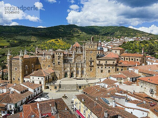 Luftaufnahme eines alten Klosters mit roten Dächern und umliegenden Hügeln unter einem blauen Himmel in Spanien. Die Architektur ist historisch und mittelalterlich  Luftaufnahme  Wallfahrtskirche und Kloster  Real Monasterio de Nuestra Señora de Guadalupe  Guadalupe  Provinz Cáceres  Caceres  Extremadura  Spanien  Europa