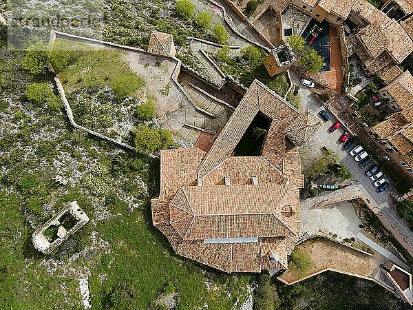 Eine Luftaufnahme einer historischen Festung mit Ziegeldächern und umliegenden Gebäuden auf steinigem Gelände  Luftaufnahme  Kollegiatkirche auf dem Hügel  Colegiata de Santa María la Mayor  Alquézar  Alquezar  Huesca  Aragón  Aragon  Pyrenäen  Spanien  Europa