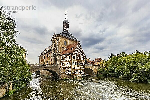 Altes Rathaus auf einer künstlichen Insel im Fluss Regnitz. Erreichbar ist das Wahrzeichen über zwei Bogenbrücken. Stadtansicht Bamberg  Oberfranken  Bayern  Deutschland  Europa