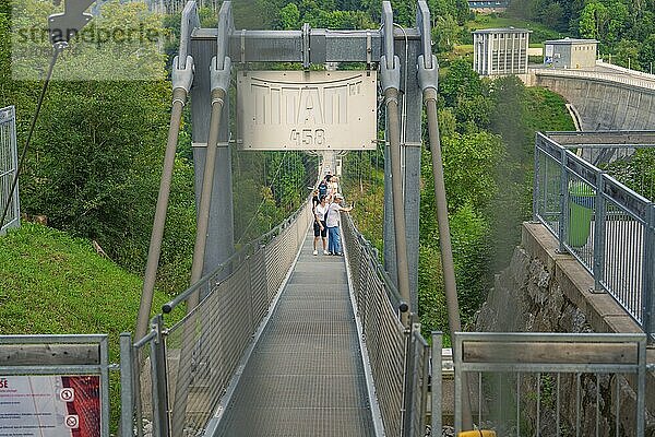 Menschen überqueren eine Metallhängebrücke  die über eine grüne Schlucht führt  Rappbodetalsperre  Harz  Deutschland  Europa