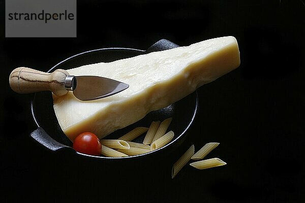 Ein Stück Parmesankäse mit Käsemesser  Teigwaren und Tomaten  Italien  Europa