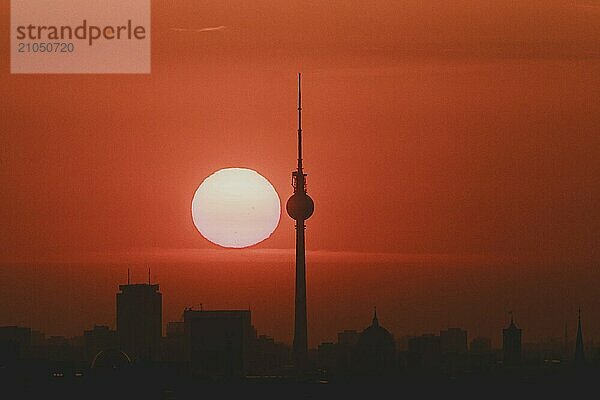 Der Sonnenaufgang zeichnet sich ab hinter der Stadtsilhouette mit dem Fernsehturm in Berlin  04.09.2024