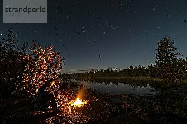 Mann abends am Biwak mit Lagerfeuer  Lappland  Schweden  Skandinavien  Europa