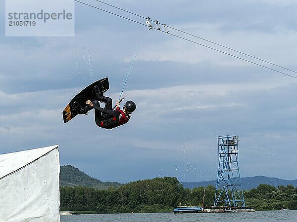 Mann bei Sprung mit Wakeboard über Hindernis  Salto  Wassersport  Wasserski und Wakepark  Stráž pod Ralskem  Tschechin