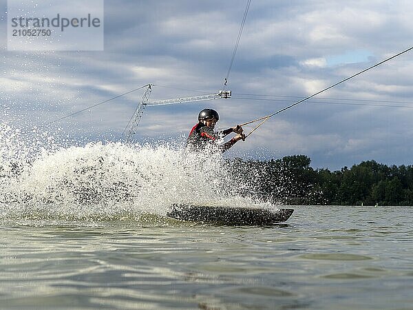 Mann fährt rasant mit Wakeboard  Wassersport  Wasserski und Wakepark  Stráž pod Ralskem  Tschechin