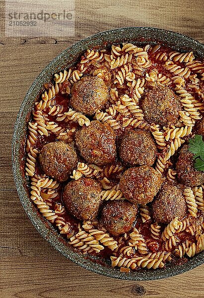 Hackfleischbällchen in Tomatensauce  mit Fusilli Nudeln  in einer gusseisernen Pfanne  hausgemacht  ohne Menschen