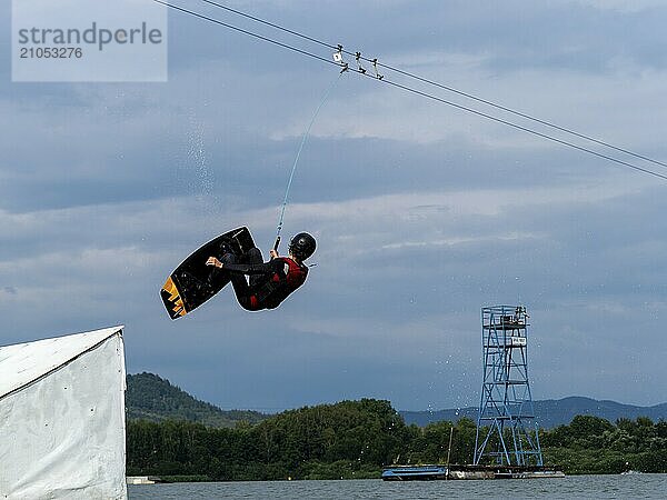 Mann bei Sprung mit Wakeboard über Hindernis  Salto  Wassersport  Wasserski und Wakepark  Stráž pod Ralskem  Tschechin