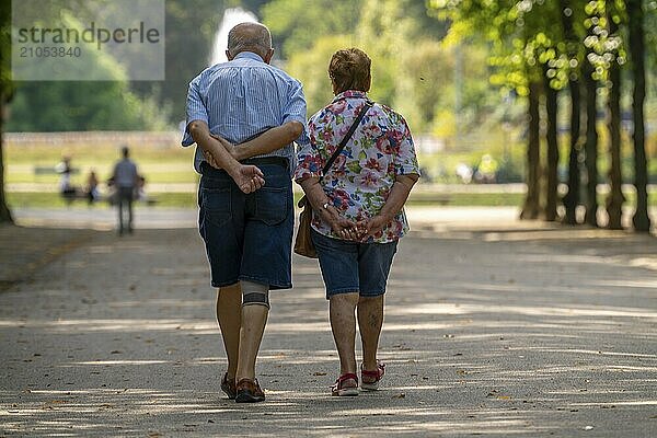 Die Jägerhofallee im Hofgarten dem zentralen Stadtpark in Düsseldorf  Blick auf die Fontäne Jröner Jong  im rundenTeich  Senioren Paar  Nordrhein-Westfalen  Deutschland  Europa