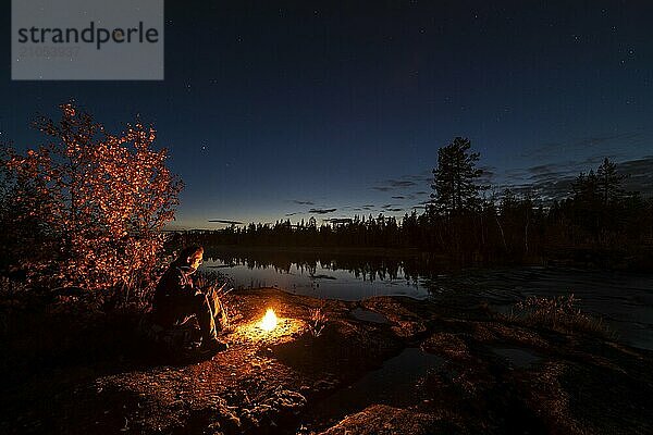 Mann abends am Biwak mit Lagerfeuer  Lappland  Schweden  Skandinavien  Europa