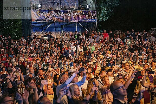 Große Menschenmenge bei Nachtkonzert mit Bühne und Begrüßungsbanner im Hintergrund  Klostersommer  Calw Hirsau  Schwarzwald  Deutschland  Europa