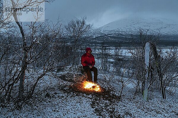 Mann am Lagerfeuer  Stora Sjöfallet Nationalpark  Welterbe Laponia  Norrbotten  Lappland  Schweden  April 2018  Lappland  Schweden  Europa