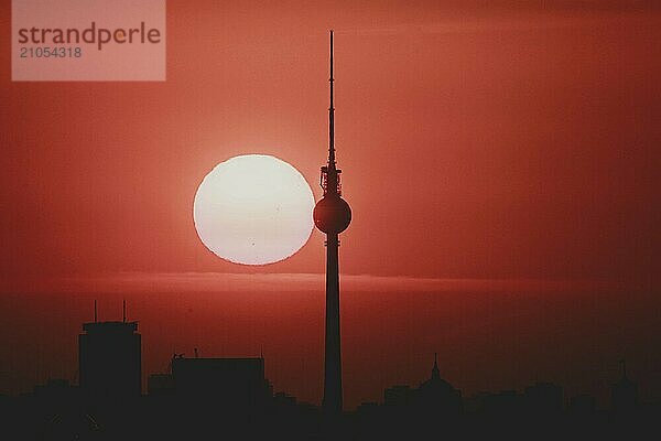 Der Sonnenaufgang zeichnet sich ab hinter der Stadtsilhouette mit dem Fernsehturm in Berlin  04.09.2024