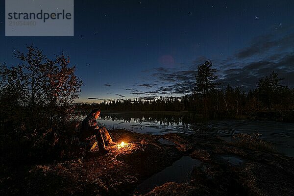 Mann abends am Biwak mit Lagerfeuer  Lappland  Schweden  Skandinavien  Europa