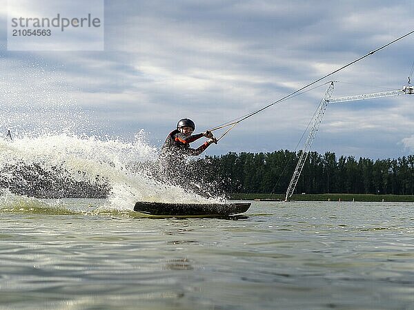 Mann fährt rasant mit Wakeboard  Wassersport  Wasserski und Wakepark  Stráž pod Ralskem  Tschechin