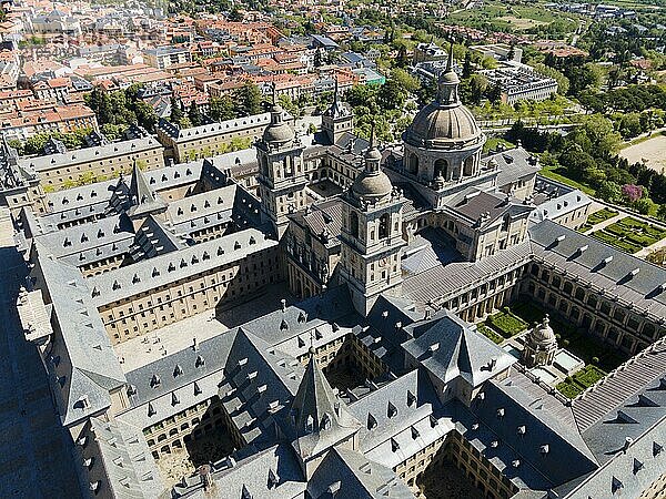 Luftaufnahme eines historischen Klosters mit Türmen und nahegelegener Stadt  umgeben von grüner Landschaft  Luftaufnahme  Real Sitio de San Lorenzo de El Escorial  Königlicher Sitz des heiligen Laurentius von El Escorial  Palastanlage und Klosteranlage  San Lorenzo de El Escorial  Madrid  Spanien  UNESCO-Weltkulturerbe  Europa