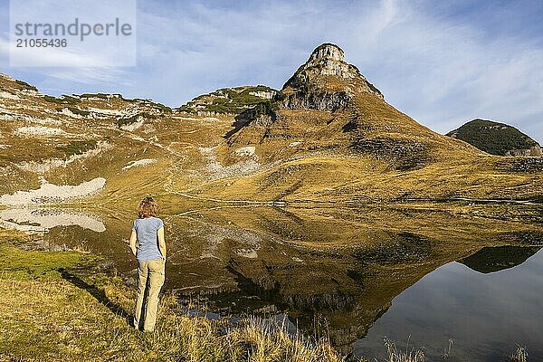 Augstsee und der Berg Atterkogel auf dem Loser. Eine Wanderin steht am Ufer. Herbst  gutes Wetter  blauer Himmel. Spiegelung. Altaussee  Bad Aussee  Ausseer Land  Totes Gebirge  Steiermark  Oberösterreich  Österreich  Europa