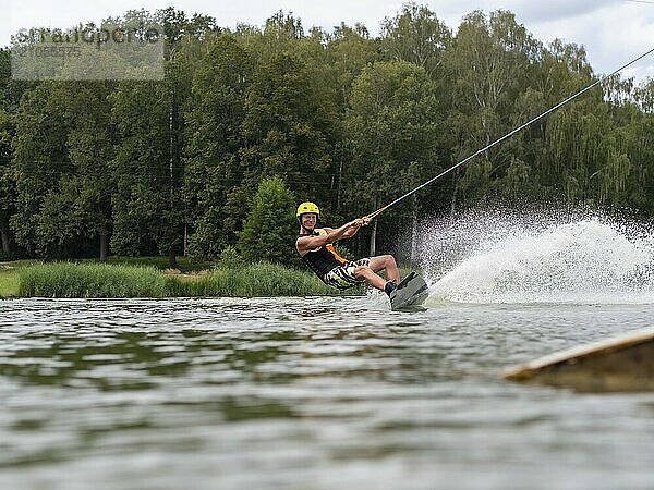 Sportlicher Mann mit Wakeboard  Wassersport  Wasserski und Wakepark