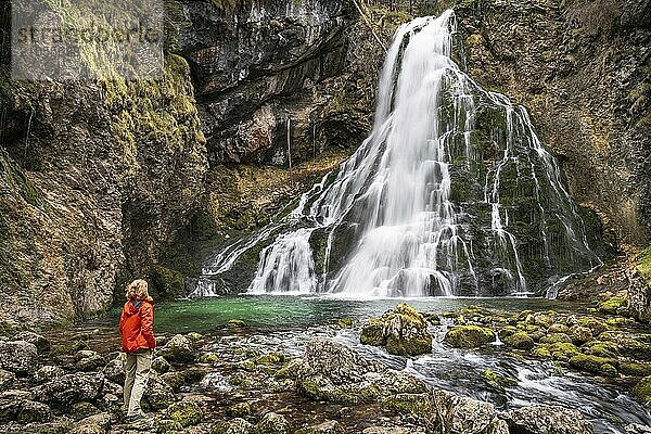 Eine Wanderin am Gollinger Wasserfall (Schwarzbachfall  Schwarzenbachfall) im Herbst. Felsen mit Moos. Tennengau  Salzburger Land  Oberösterreich  Österreich  Europa