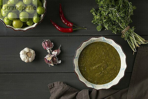 Tkemali Sauce  traditionelle georgische Küche  grüne Kirschpflaume  mit Zutaten für die Sauce  Koriander  Minze  scharfer Pfeffer  Knoblauch  auf einem Holztisch  Nahaufnahme  rustikal  Lebensmittel Hintergrund  keine Menschen  selektiver Fokus  Sauce  grüne Sauce  tkemali  georgische Küche  hausgemacht