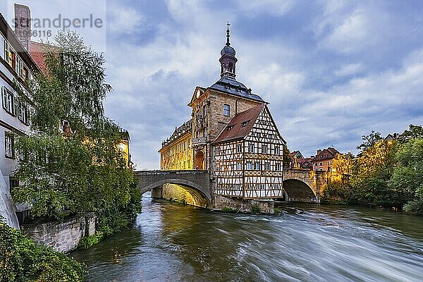 Altes Rathaus auf einer künstlichen Insel im Fluss Regnitz. Erreichbar ist das Wahrzeichen über zwei Bogenbrücken. Nachtaufnahme. Stadtansicht Bamberg  Oberfranken  Bayern  Deutschland  Europa