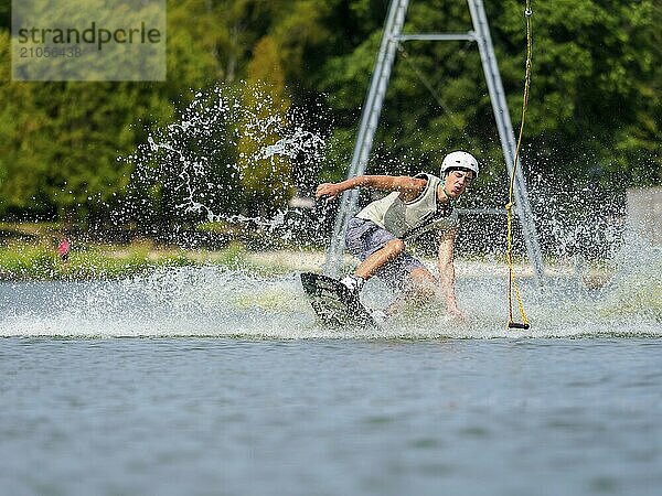 Junger Mann auf Wakeboard im Wasser beim Sturz  Wasserski und Wakepark  Wassersport