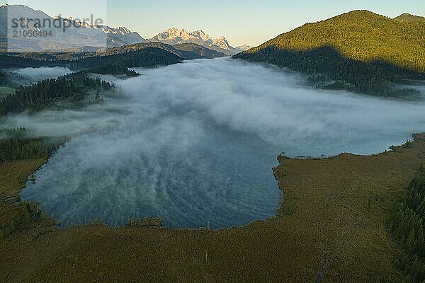 Luftaufnahme eines Bergsees vor Bergen  Sonnenaufgang  Nebel  Herbst  Barmsee  Blick auf Zugspitze und Wettersteingebirge  Oberbayern  Bayern  Deutschland  Europa