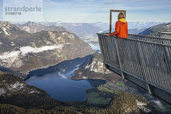 Eine Wanderin steht auf dem Aussichtspunkt 5fingers. Blick vom Dachstein Krippenstein auf den Hallstätter See. Links Hallstatt  rechts Obertraun. Herbst  gutes Wetter. Einige Wolken in den Bergen. Hallstätter See  Salzkammergut  Oberösterreich  Österreich  Europa