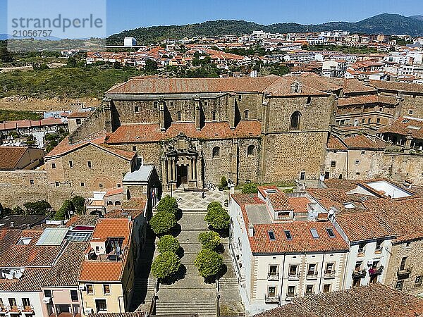 Große historische Kirche mit breiten Treppen und umgeben von alten Gebäuden mit roten Dächern in einer hügeligen Landschaft  Luftaufnahme  Plasencia  Cáceres  Caceres  Extremadura  Spanien  Europa