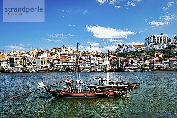 Blick auf die Stadt Porto und den Fluss Douro mit einem traditionellen Boot mit Portweinfässern vom berühmten touristischen Aussichtspunkt Marginal de Gaia am Flussufer. Porto  Vila Nova de Gaia  Portugal  Europa