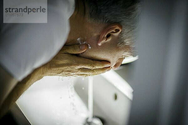 Ein Mann wäscht sich das Gesicht mit Wasser. Berlin  13.08.2024