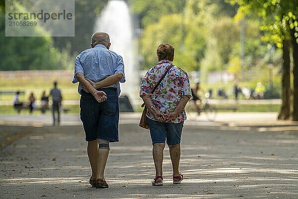 Die Jägerhofallee im Hofgarten dem zentralen Stadtpark in Düsseldorf  Blick auf die Fontäne Jröner Jong  im rundenTeich  Senioren Paar  Nordrhein-Westfalen  Deutschland  Europa