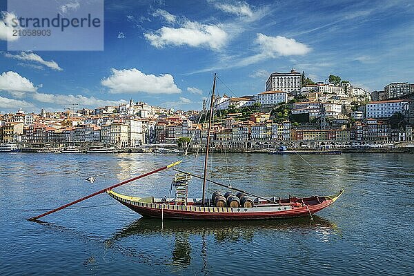 Blick auf die Stadt Porto und den Fluss Douro mit einem traditionellen Boot mit Portweinfässern vom berühmten touristischen Aussichtspunkt Marginal de Gaia am Flussufer. Porto  Vila Nova de Gaia  Portugal  Europa