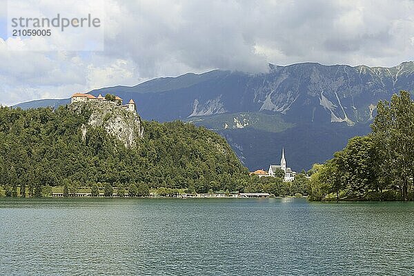 Bleder See Slowenien. Schöne Bergsee im Sommer mit kleinen Kirche auf einer Insel mit Schloss auf Klippe und europäischen Alpen im Hintergrund