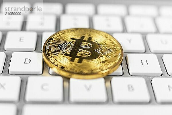 Bitcoin Münze auf weißer Computertastatur liegend