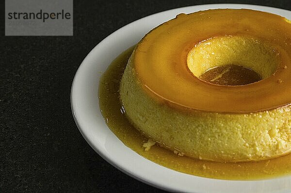 Traditionelle brasilianische Nachspeise  Milchpudding auf dunklem Hintergrund