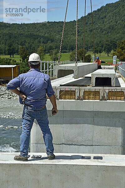 Bauarbeiter errichten eine Betonbrücke über einen kleinen Fluss in Westland  Neuseeland  Ozeanien