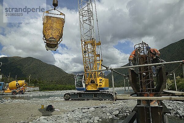 Bauarbeiter errichten eine Betonbrücke über einen kleinen Fluss in Westland  Neuseeland  Ozeanien