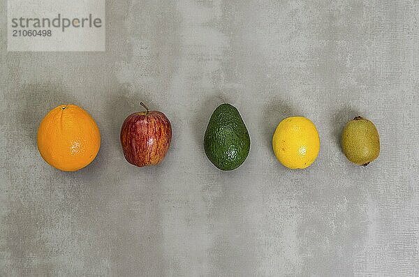 Großes Konzept der gesunden Ernährung  verschiedene Früchte auf grauem Hintergrund  poliertem Beton. Orange  Apfel  Kiwi  Zitrone