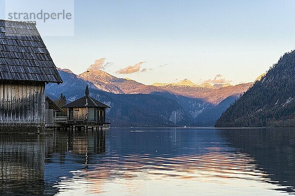 Der Grundlsee im Herbst bei Sonnenuntergang. Links Bootshäuser  im Hintergrund Berge. Blauer Himmel  gutes Wetter. Grundlsee  Steiermark bzw. Steirisches Salzkammergut  Oberösterreich  Österreich  Europa