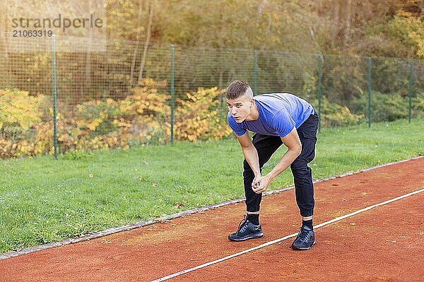 Junger Mann joggt morgens im Freien auf der Laufstrecke