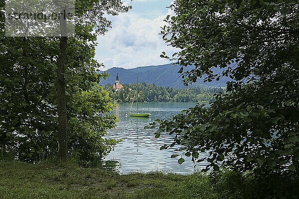 Bleder See Slowenien. Schöne Bergsee im Sommer mit kleinen Kirche auf einer Insel mit Schloss auf Klippe und europäischen Alpen im Hintergrund