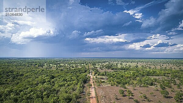 Luftaufnahme der unbefestigten Transpantaneira Straße mit dramatischem Himmel und Regen  die die typische Landschaft im nördlichen Pantanal Feuchtgebiet  Mato Großo  Brasilien  durchquert  Südamerika