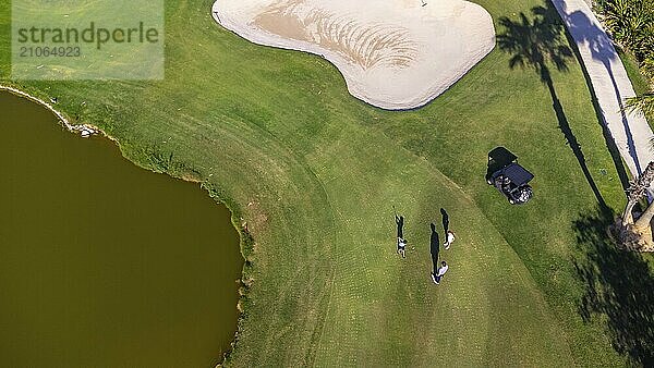 Luftaufnahme eines Sees auf einem Golfplatz und Menschen  die darauf spielen