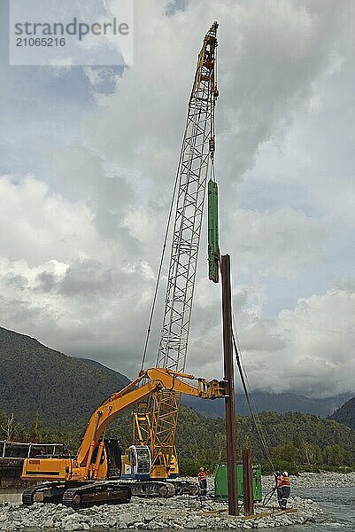 Männer richten einen Pfahl für eine neue Brücke über einen Westland Fluss aus  Neuseeland  Ozeanien