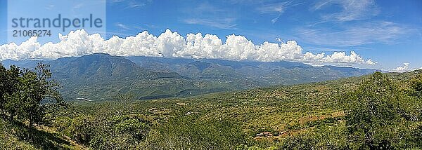 Panorama des wunderschönen Ausblicks von Barichara  Kolumbien  über die grüne Landschaft zu den Bergen mit blauem Himmel und weißen Wolken entlang des Bergkamms  Südamerika